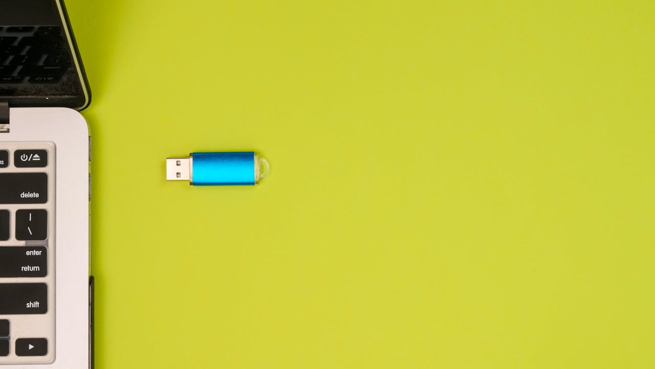 USB drive and a computer against yellow background
